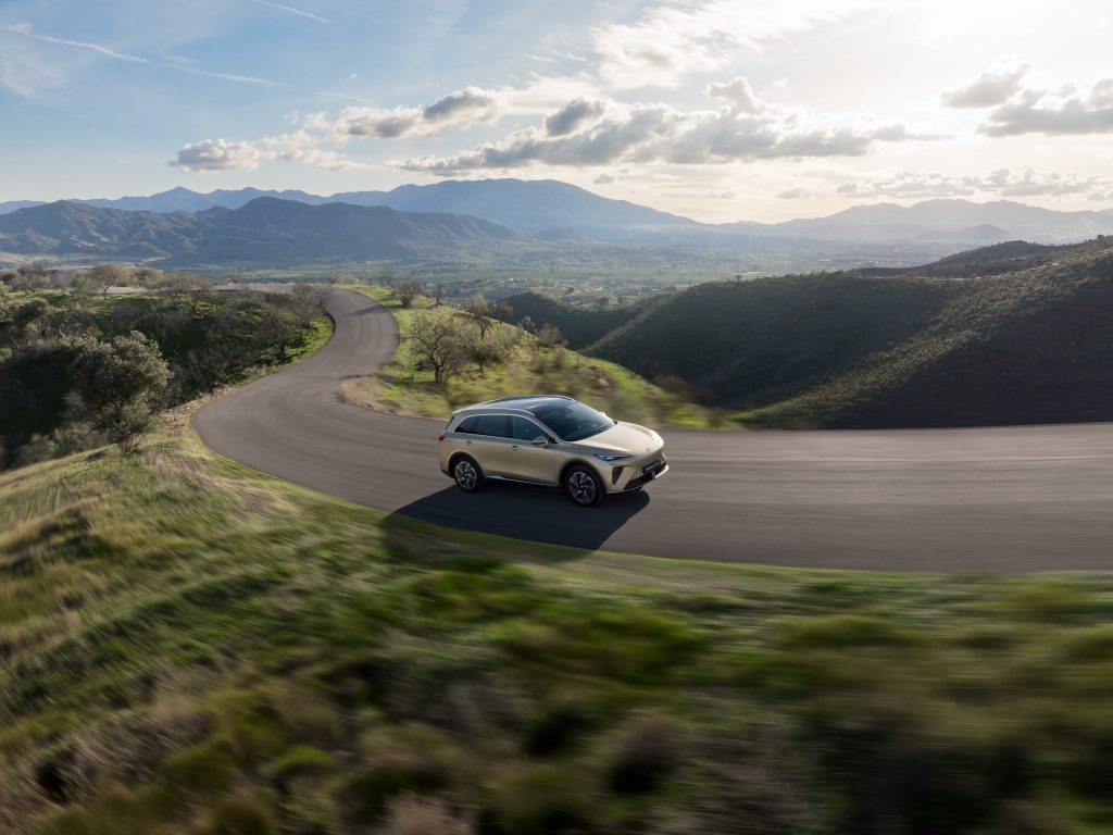 mgs6-ev-elektro-suv-fahrt-bergstrasse.jpg MGS6 EV Elektro-SUV fährt dynamisch über eine kurvige Bergstraße in einer weiten Landschaft