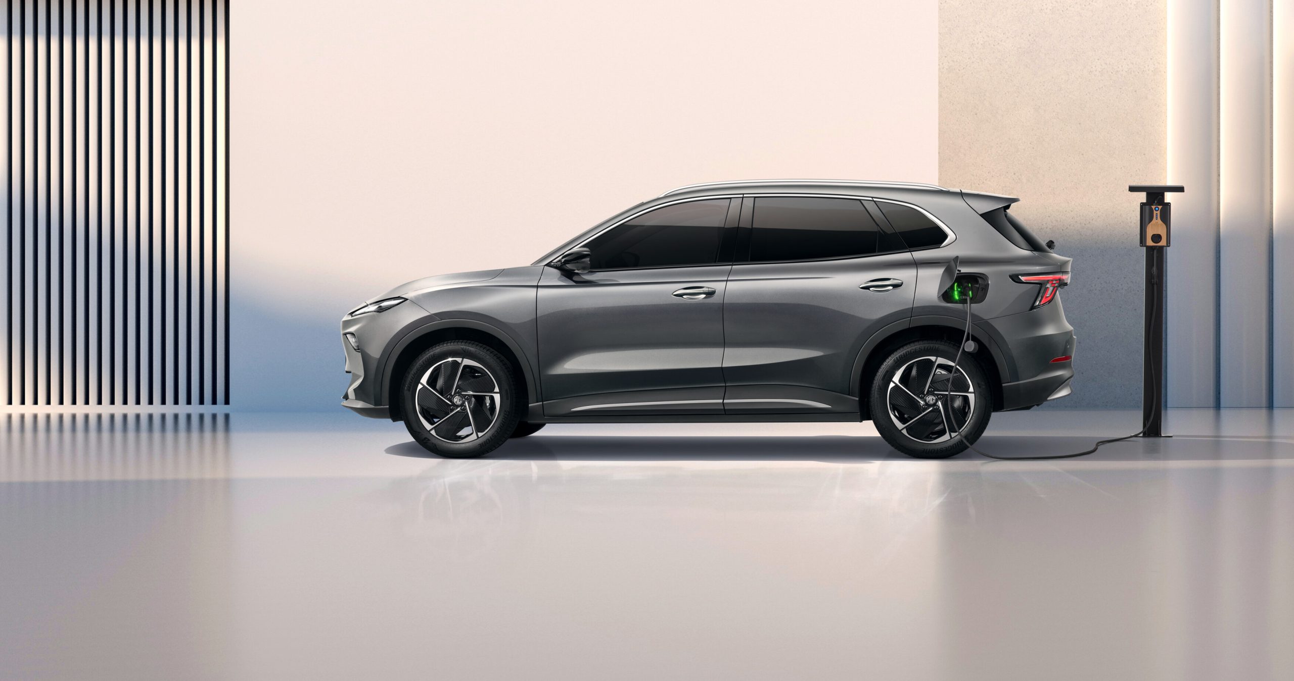 MG S5 EV lädt an einer Ladesäule, Seitenansicht, graues Fahrzeug.